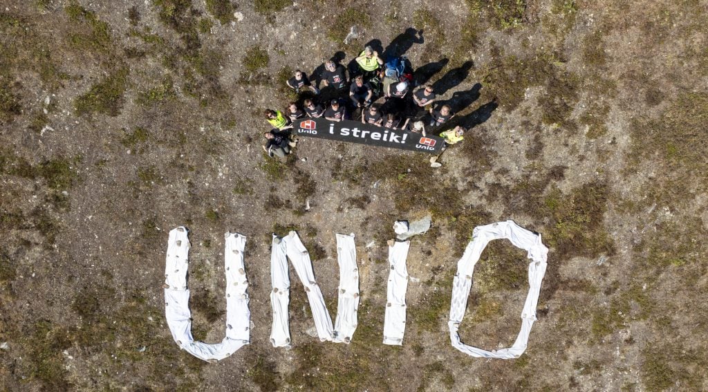 En gruppe mennesker foran teksten "Unio". Foto.